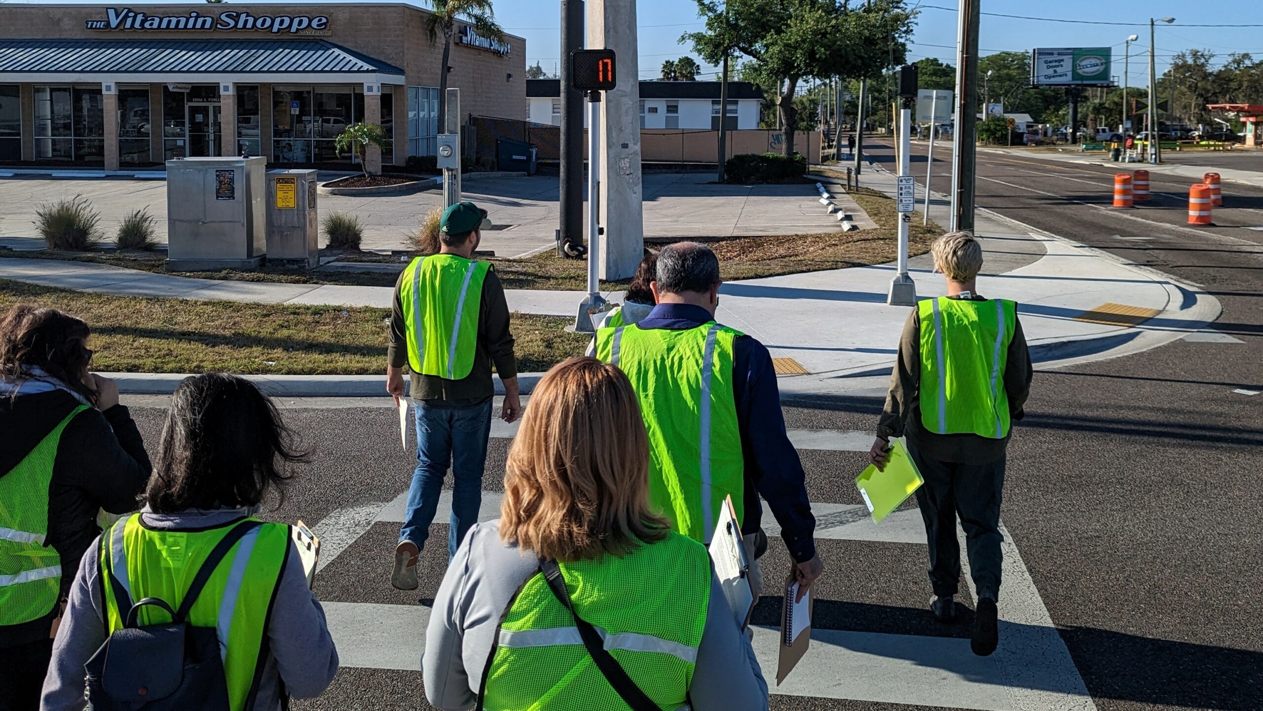 people in safety vests in a crosswalk