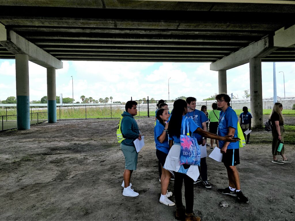 Group of diverse flip students discussing a group project under the Selmon Expressway