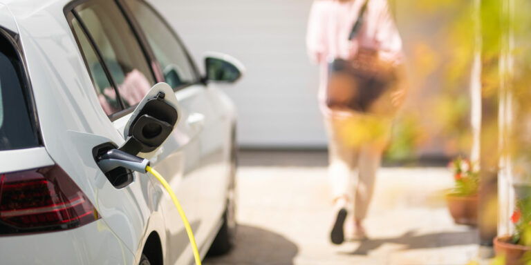 Electric car charger with female silhouette in the background