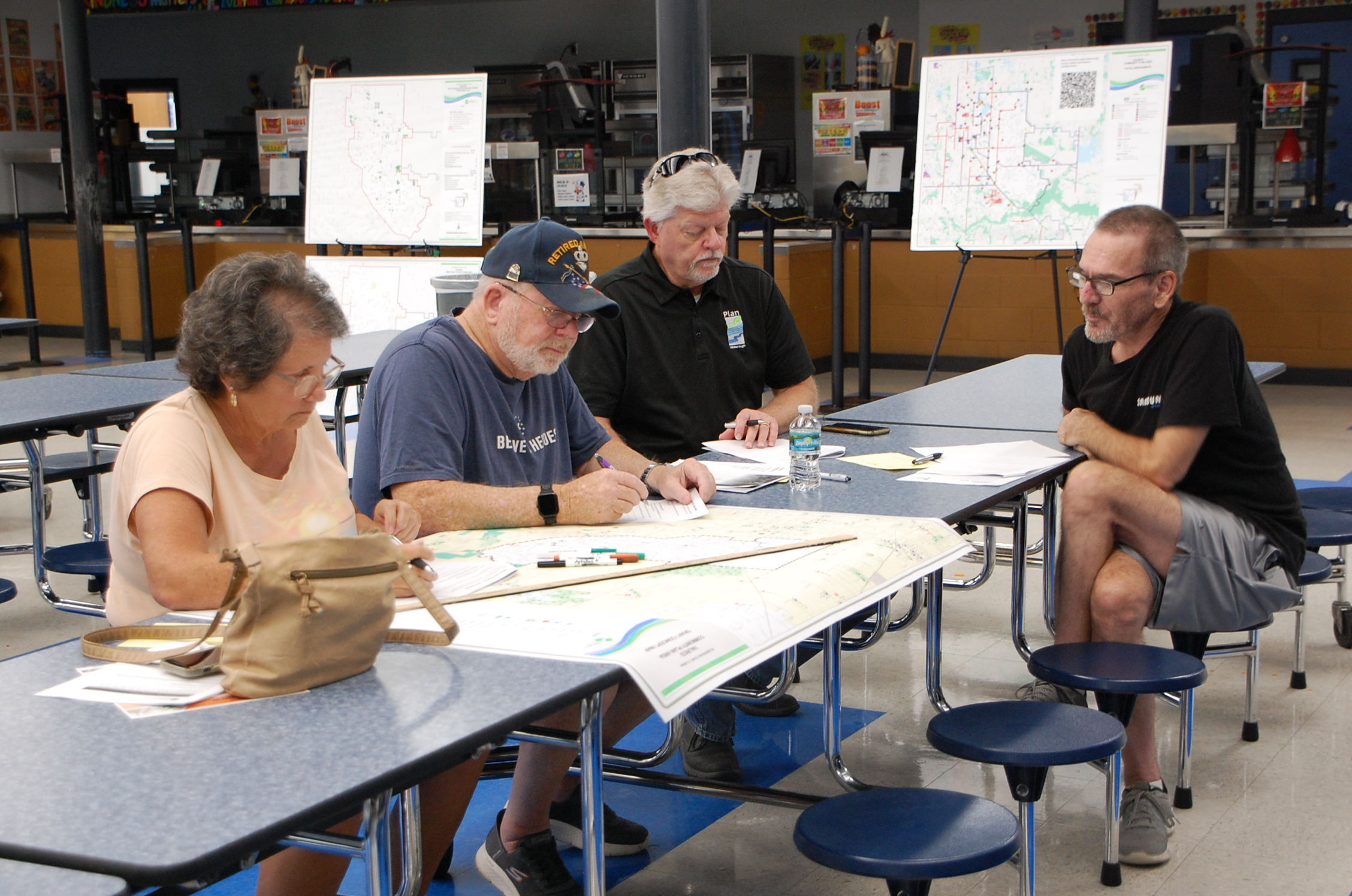 Community members sitting at a table drawing on a map of Valrico.