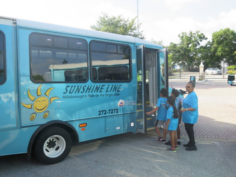 Community members boarding Sunshine Line Bus