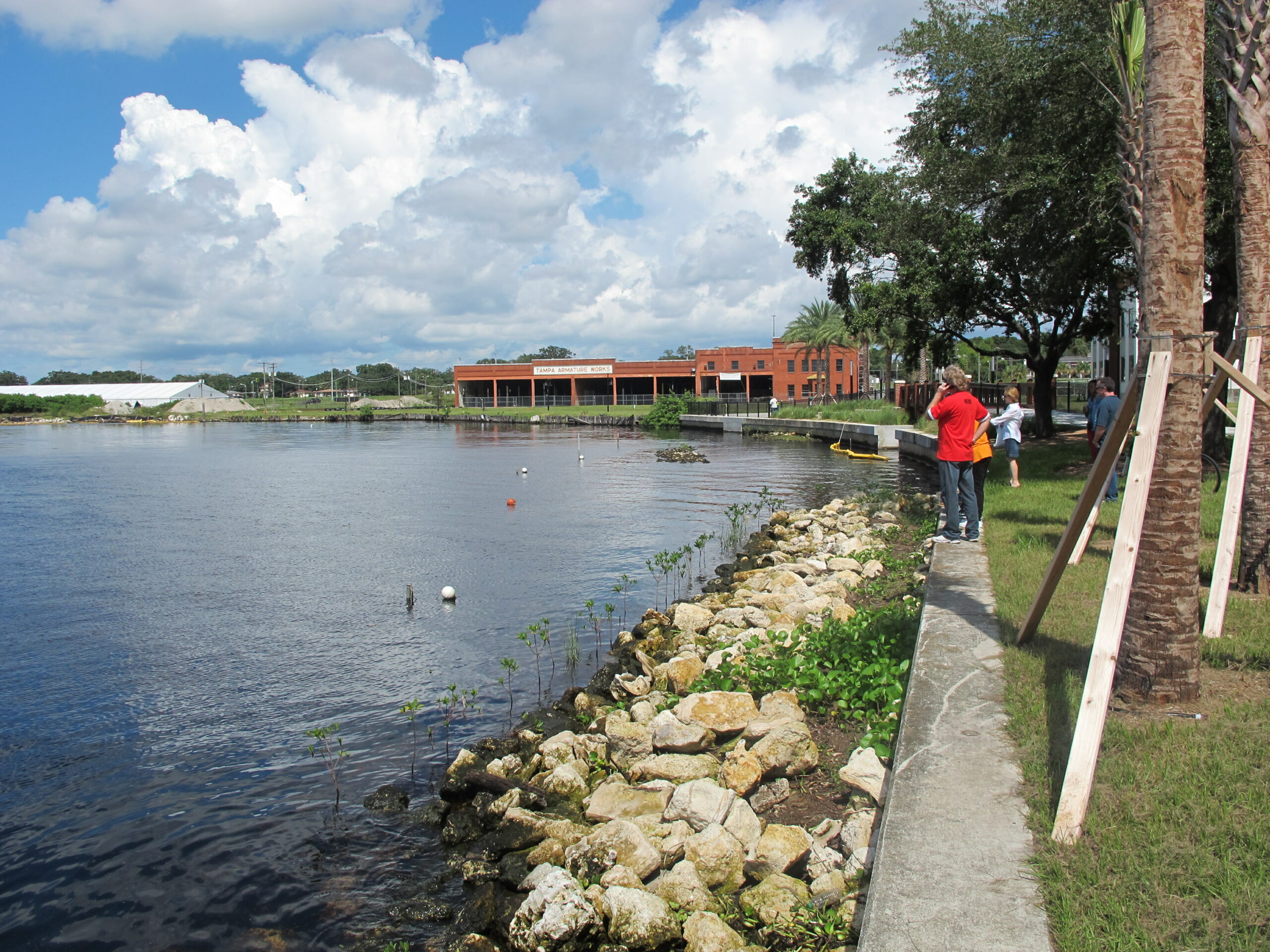 People standing alongside the Hillsborough River at waterworks park.