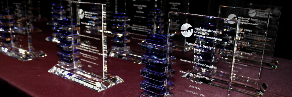 Clear and blue rectangular crystal awards sitting on top of a red table cloth.